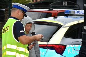 Policjanci wraz z przedstawicielami komisji wręczają ulotki
