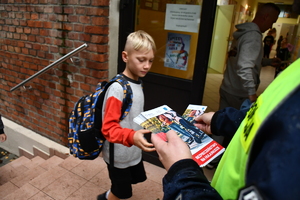 Policjanci wraz z przedstawicielami komisji wręczają ulotki
