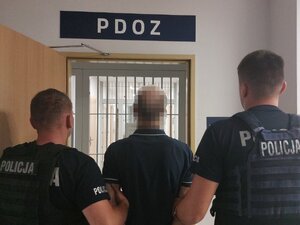 Policjanci trzymający skutego mężczyznę