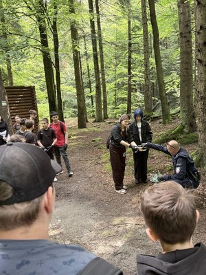 dzielnicowy i młodzież podczas znakowania szlaku turystycznego
