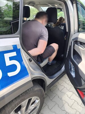 Skuty mężczyzna siedzący w radiowozie