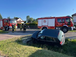 Zdjęcie przedstawia miejsce zdarzenia drogowego w Wierzawicach. Na zdjęciu widać uszkodzony pojazd marki Volkswagen. W kadrze zdjęcia widoczny jest również samochód straży pożarnej oraz radiowóz policji. Na zdjęciu widoczni są również umundurowani funkcjonariusze straży pożarnej oraz policji.