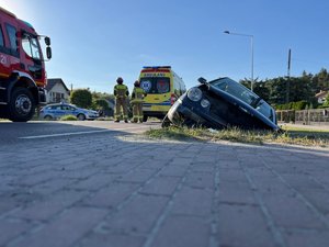 Zdjęcie przedstawia miejsce zdarzenia drogowego w Wierzawicach. Na zdjęciu widać uszkodzony pojazd marki Volkswagen. W kadrze zdjęcia widoczny jest również samochód straży pożarnej oraz radiowóz policji. Na zdjęciu widoczni są również umundurowani funkcjonariusze straży pożarnej oraz policji.