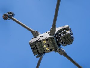 Zdjęcia przedstawiają policyjnego drona z Komendy Powiatowej Policji w Leżajsku, tj. bezzałogowy statek powietrzny, aparaturę sterującą oraz sytuację kiedy dron jest w powietrzu nad oznakowanym radiowozem.