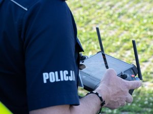 Zdjęcia przedstawiają policyjnego drona z Komendy Powiatowej Policji w Leżajsku, tj. bezzałogowy statek powietrzny, aparaturę sterującą oraz sytuację kiedy dron jest w powietrzu nad oznakowanym radiowozem.