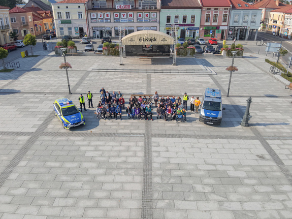 Zdjęcia przedstawiają przebieg zajęć profilaktycznych , które odbyły się na leżajskim rynku. Na zdjęciach widać umundurowanych funkcjonariuszy z leżajskiej komendy. Widać także inne osoby biorące udział w spotkaniu. Dodatkowo na zdjęciach widoczne są oznakowane radiowozy policji. Zdjęcia wykonywane były z ziemi jak również z drona.