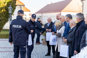 Zdjęcia przedstawiają uroczyste przekazanie nowego radiowozu dla Komendy Powiatowej Policji w Leżajsku. Spotkanie miało miejsce przy Muzeum Ziemi Leżajskiej. W przekazaniu udział wzięli przedstawiciele jednostek samorządu lokalnego. Na zdjęciach znajdują się także umundurowani funkcjonariusze oraz oznakowany radiowóz.