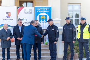 Zdjęcia przedstawiają uroczyste przekazanie nowego radiowozu dla Komendy Powiatowej Policji w Leżajsku. Spotkanie miało miejsce przy Muzeum Ziemi Leżajskiej. W przekazaniu udział wzięli przedstawiciele jednostek samorządu lokalnego. Na zdjęciach znajdują się także umundurowani funkcjonariusze oraz oznakowany radiowóz.