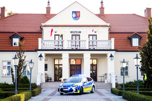 Zdjęcia przedstawiają uroczyste przekazanie nowego radiowozu dla Komendy Powiatowej Policji w Leżajsku. Spotkanie miało miejsce przy Muzeum Ziemi Leżajskiej. W przekazaniu udział wzięli przedstawiciele jednostek samorządu lokalnego. Na zdjęciach znajdują się także umundurowani funkcjonariusze oraz oznakowany radiowóz.