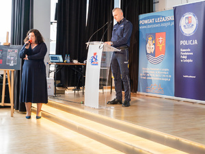 Zdjęcia przedstawiają przebieg debaty. Na zdjęciach widoczni są umundurowani policjanci oraz prelegenci. Debata społeczna odbyła się w Zespole Szkół Licealnych im. Bolesława Chrobrego. Na wybranych kadrach widoczna jest tłumnie zgromadzona na sali koncertowej młodzież.