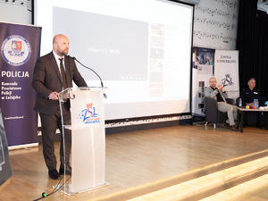 Zdjęcia przedstawiają przebieg debaty. Na zdjęciach widoczni są umundurowani policjanci oraz prelegenci. Debata społeczna odbyła się w Zespole Szkół Licealnych im. Bolesława Chrobrego. Na wybranych kadrach widoczna jest tłumnie zgromadzona na sali koncertowej młodzież.