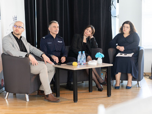 Zdjęcia przedstawiają przebieg debaty. Na zdjęciach widoczni są umundurowani policjanci oraz prelegenci. Debata społeczna odbyła się w Zespole Szkół Licealnych im. Bolesława Chrobrego. Na wybranych kadrach widoczna jest tłumnie zgromadzona na sali koncertowej młodzież.