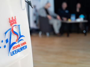 Zdjęcia przedstawiają przebieg debaty. Na zdjęciach widoczni są umundurowani policjanci oraz prelegenci. Debata społeczna odbyła się w Zespole Szkół Licealnych im. Bolesława Chrobrego. Na wybranych kadrach widoczna jest tłumnie zgromadzona na sali koncertowej młodzież.