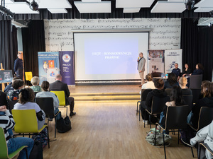 Zdjęcia przedstawiają przebieg debaty. Na zdjęciach widoczni są umundurowani policjanci oraz prelegenci. Debata społeczna odbyła się w Zespole Szkół Licealnych im. Bolesława Chrobrego. Na wybranych kadrach widoczna jest tłumnie zgromadzona na sali koncertowej młodzież.