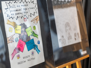 Zdjęcia przedstawiają przebieg debaty. Na zdjęciach widoczni są umundurowani policjanci oraz prelegenci. Debata społeczna odbyła się w Zespole Szkół Licealnych im. Bolesława Chrobrego. Na wybranych kadrach widoczna jest tłumnie zgromadzona na sali koncertowej młodzież.