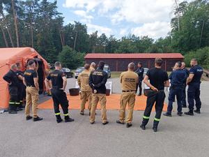 Zdjęcia przedstawiają funkcjonariuszy z Komendy Powiatowej Policji w Leżajsku oraz Komendy Powiatowej Państwowej Straży Pożarnej w Leżajsku podczas szkolenia CBRNE. NA zdjęciach widoczny jest także wóz strażacki.