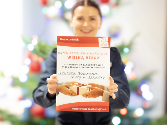 Zdjęcie przedstawia umundurowaną funkcjonariuszkę, trzymającą w rękach podziękowania za włączenie się w akcję szlachetnej paczki.