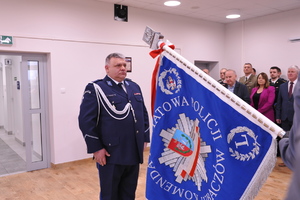 Na zdjęciu insp. Grzegorz Błaszczyk stoi przy sztandarze Komendy Powiatowej Policji w Lubaczowie.