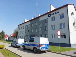 W tle budynek Komendy Powiatowej Policji w Lubaczowie, na pierwszy planie dwa oznakowane radiowozy.