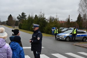 Przy przejściu dla pieszych uczniowie i policjanci.