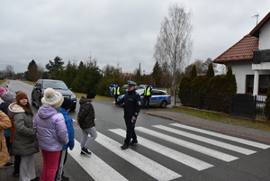 Przy przejściu dla pieszych uczniowie i policjanci.