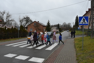 Na przejściu dla pieszych dzieci i policjanci.