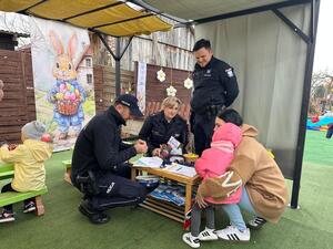 Policjanci  w umundurowaniu służbowym i uczestnicy kiermaszu.