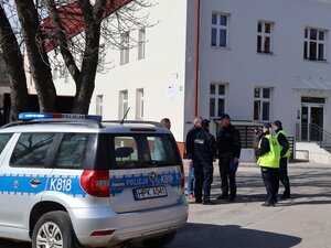 Umundurowani policjanci i oznakowany radiowóz przed Centrum Medycznym w Łańcucie.