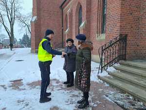 policjanci rozdają patafianom elementy odblaskowe