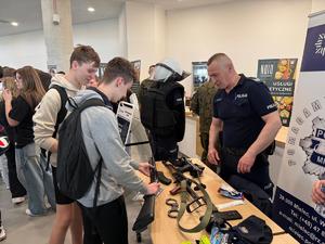 Uczestnicy XX targów edukacyjnych, policjanci w hali MOSIR w Mielcu, sprzęt policyjny i gadżety