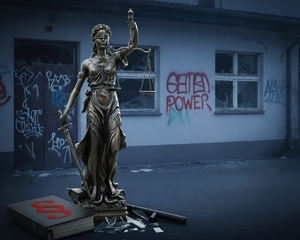temida, kodeks karny na tle zdewastowanego budynku