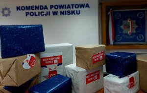 paczki ułożone na stole w tle na ścianie napis komenda powiatowa policji w nisku