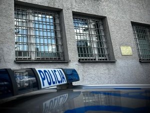 widok dachu policyjnego radiowozu z policyjną belka z napisem policja przy budynku komendy policji