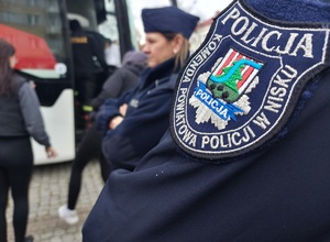 emblemat na umundurowaniu z napisem komenda powiatowa policji w nisku w tle część autobusu