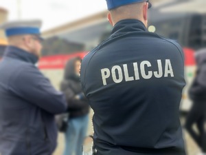policjanci stoją przed autobusem mobilnym punktem poboru krwi