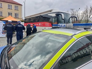 policyjny radiowóz policjanci osoby oraz autobus na placu