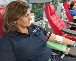 policjantka oddaje krew w mobilnym centrum autobusie