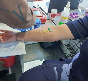 policjant oddaje krew w krwiobusie