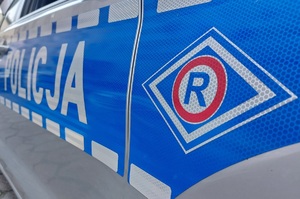 bok policyjnego radiowozu ruchu drogowego litera R w rombie