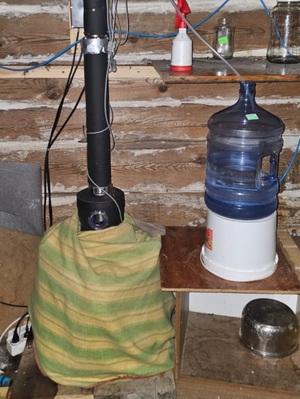 aparatura do wytwarzania alkoholu obok szklane butelki