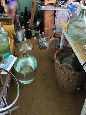 w pomieszczeniu ustawionef butelki wypełnione przezroczystą cieczą