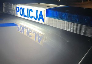 policyjna belka radiowozu z napisem policja w porze nocnej