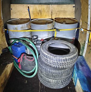 w części ładunkowej pojazdu leżą metalowe beczki opony oraz węże gumowe