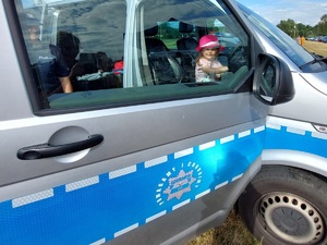 dziecko siedzi w radiowozie policyjnym typu bus