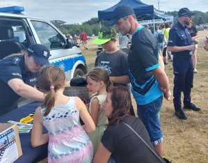 policjanci przy stoisku profilaktycznym podczas imprezy plenerowej