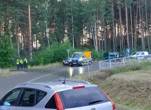 policyjny radiowóz w miejscu zabezpieczenia imprezy plenerowej widok placu i ulicy w tle umundurowani policjanci