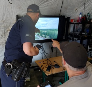 policjanci podczas obserwacji widoku z drona imprezy plenerowej