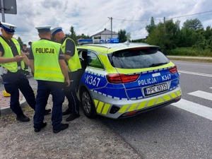 policjanci przy drodze obok radiowozu