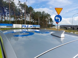 policjant stoi przy radiowozie