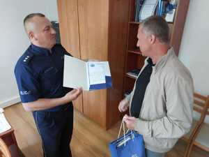 policjant wręcza mężczyźnie dyplom z podziękowaniem